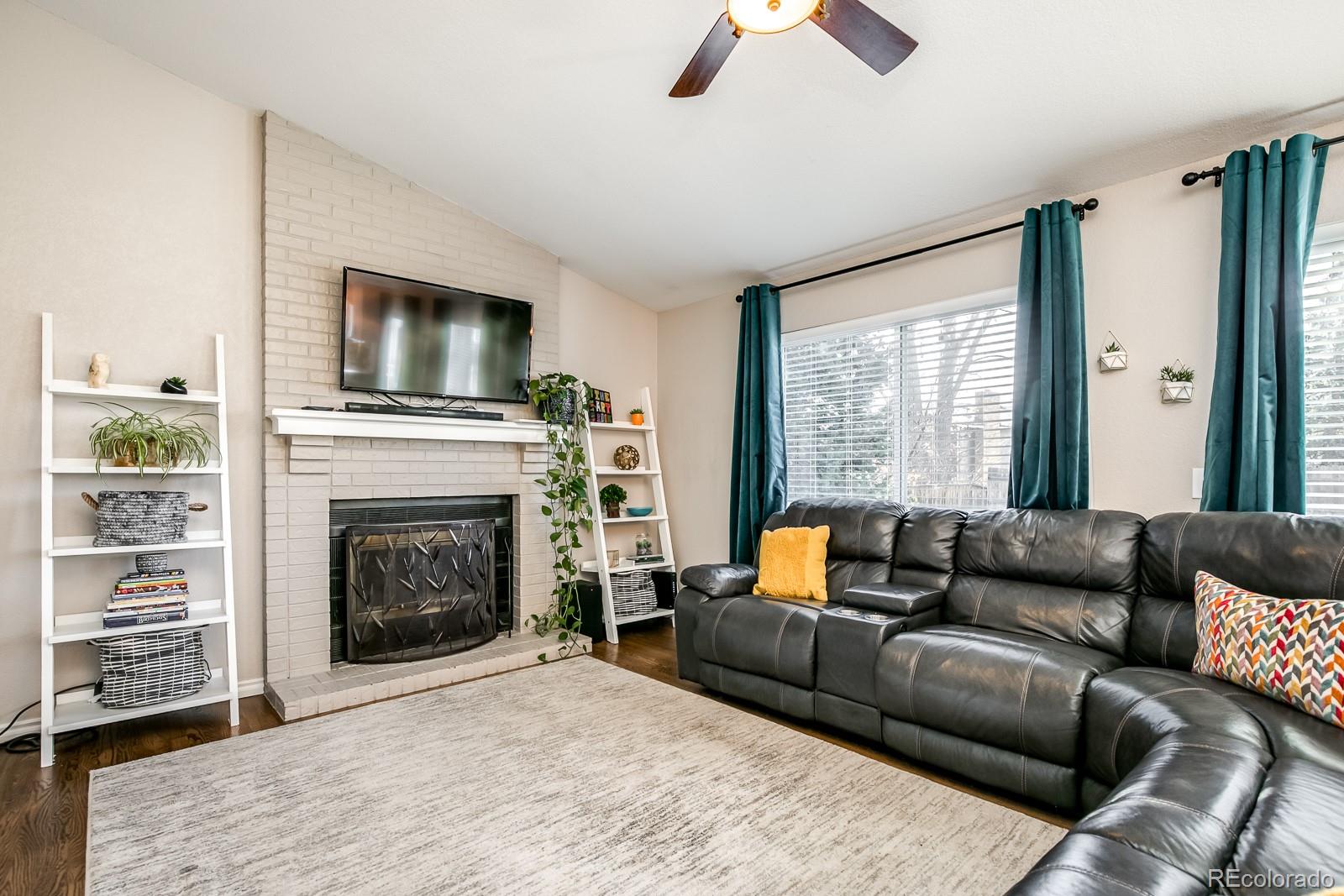 726 Northridge Road Highlands Ranch, CO 80126 - Photo 18 of 40 a living room with furniture a flat screen tv and a fireplace