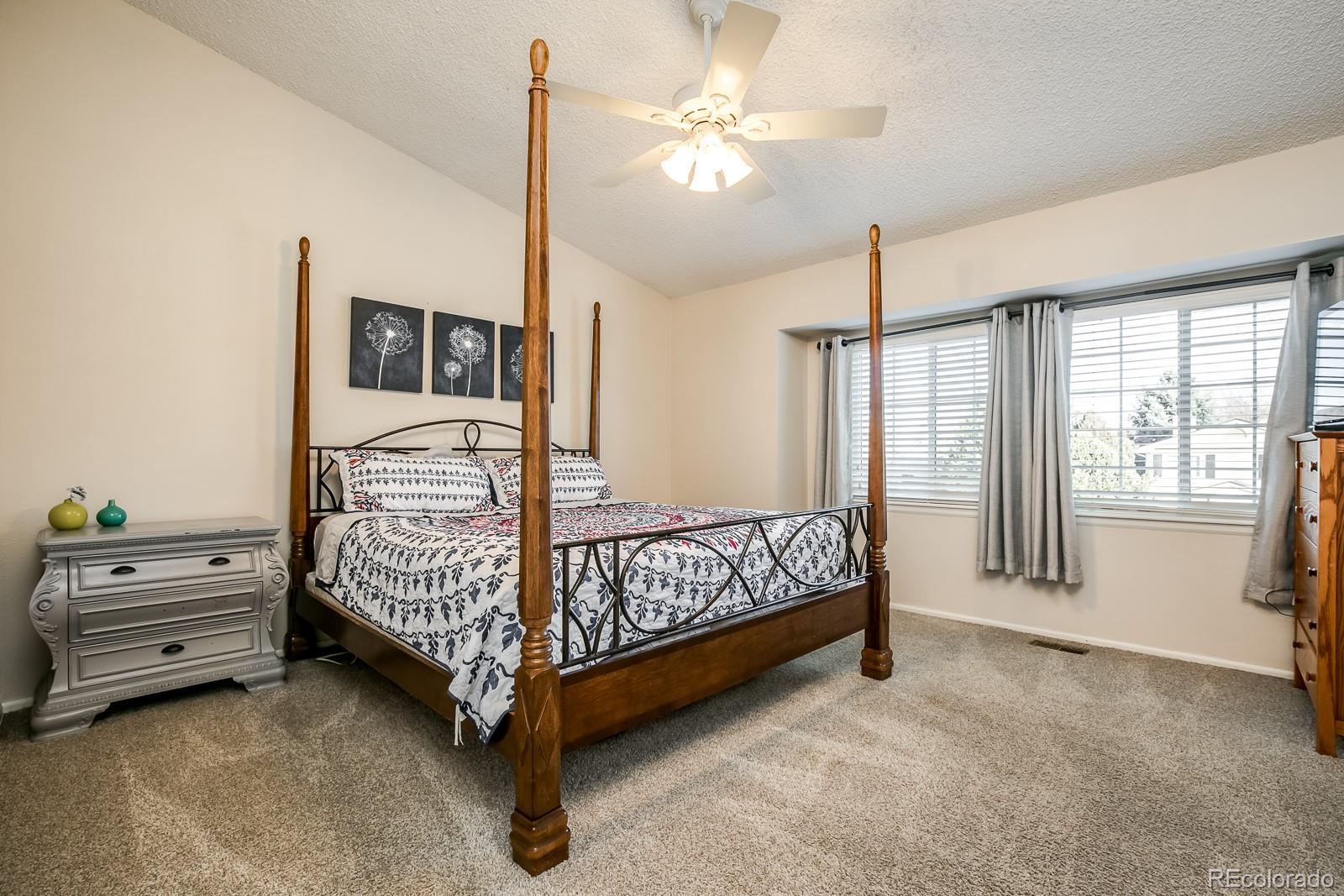 726 Northridge Road Highlands Ranch, CO 80126 - Photo 21 of 40 a bedroom with a bed and a chandelier
