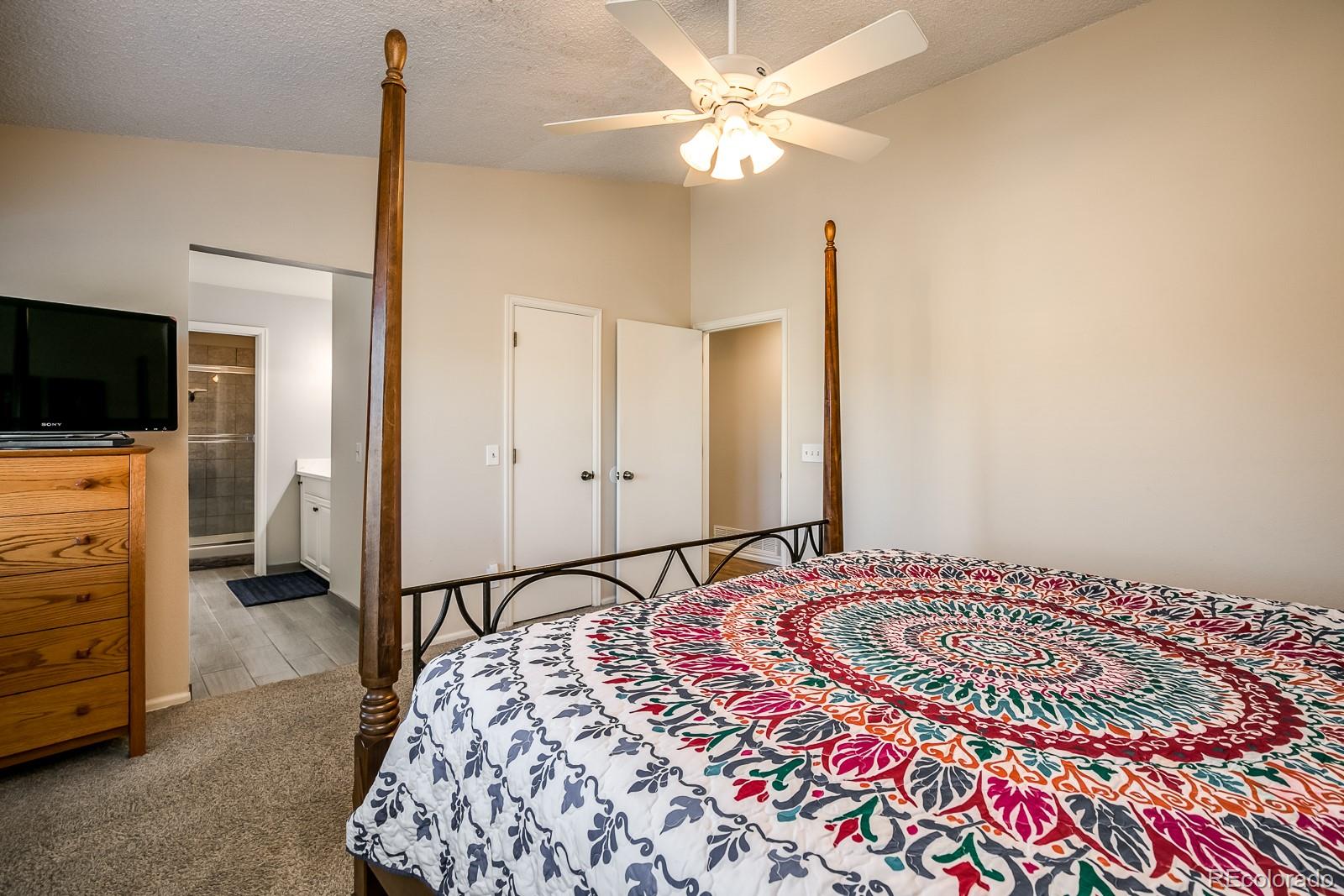 726 Northridge Road Highlands Ranch, CO 80126 - Photo 23 of 40 a bedroom with a bed and a flat screen tv