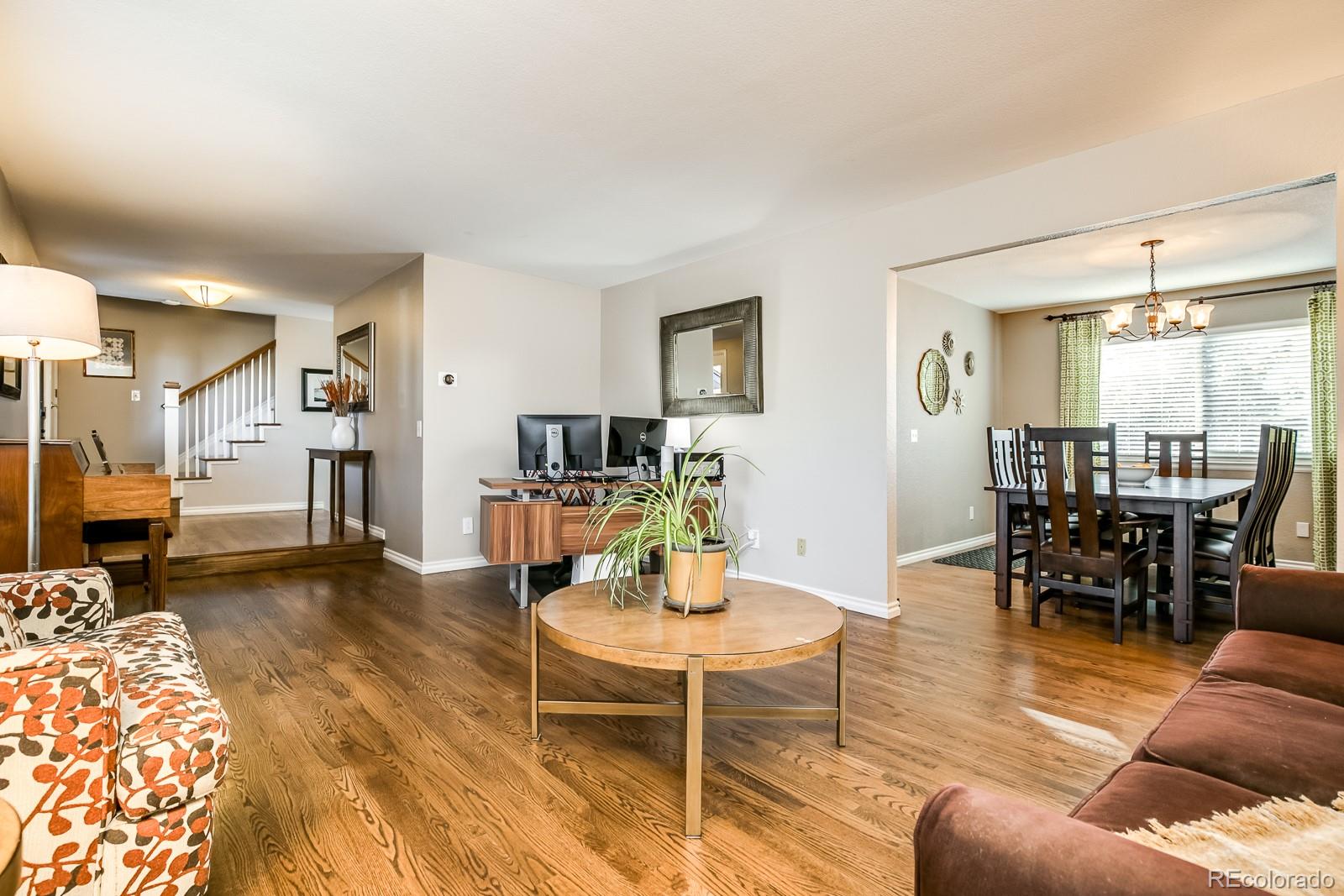 726 Northridge Road Highlands Ranch, CO 80126 - Photo 5 of 40 a living room with furniture and a dining table with wooden floor