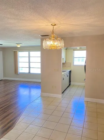 an empty room with kitchen and window