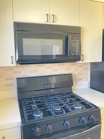 a stove top oven sitting inside of a kitchen