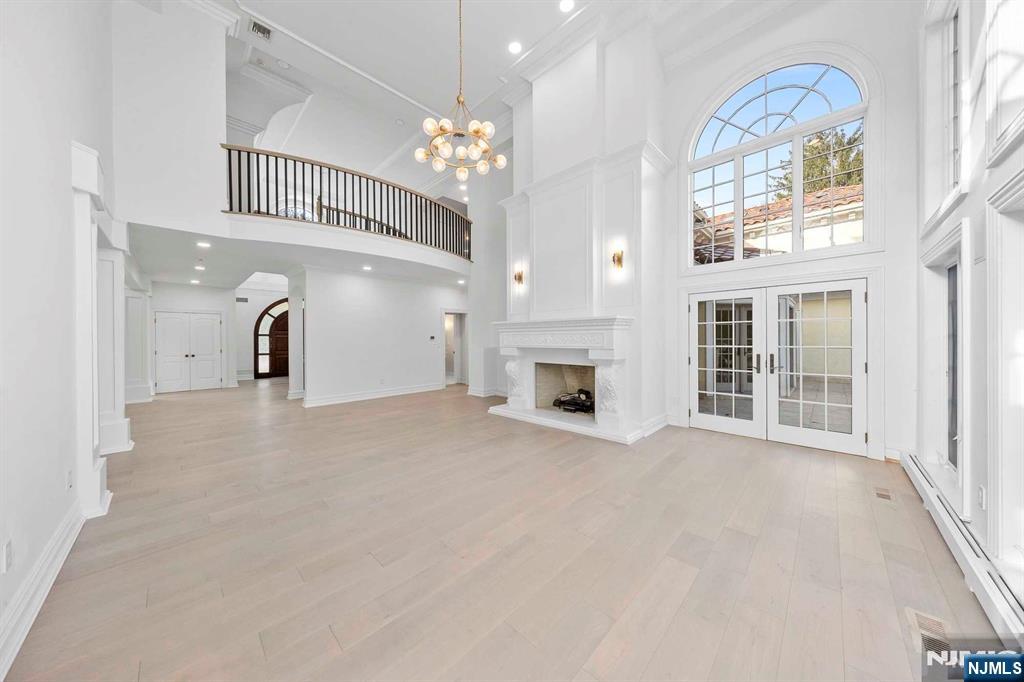 5 Ellen's Way Alpine, NJ 07620 - Photo 12 of 49 a view of a livingroom with a fireplace a chandelier and windows