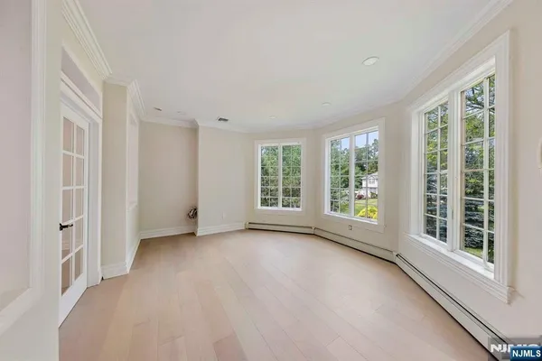 a view of a hallway with wooden floor and a door