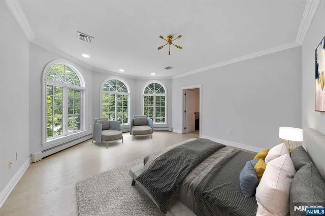 a bedroom with a large bed and a chandelier