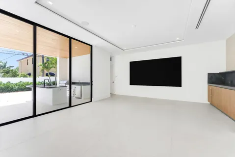 a view of an empty room with wooden floor and windows