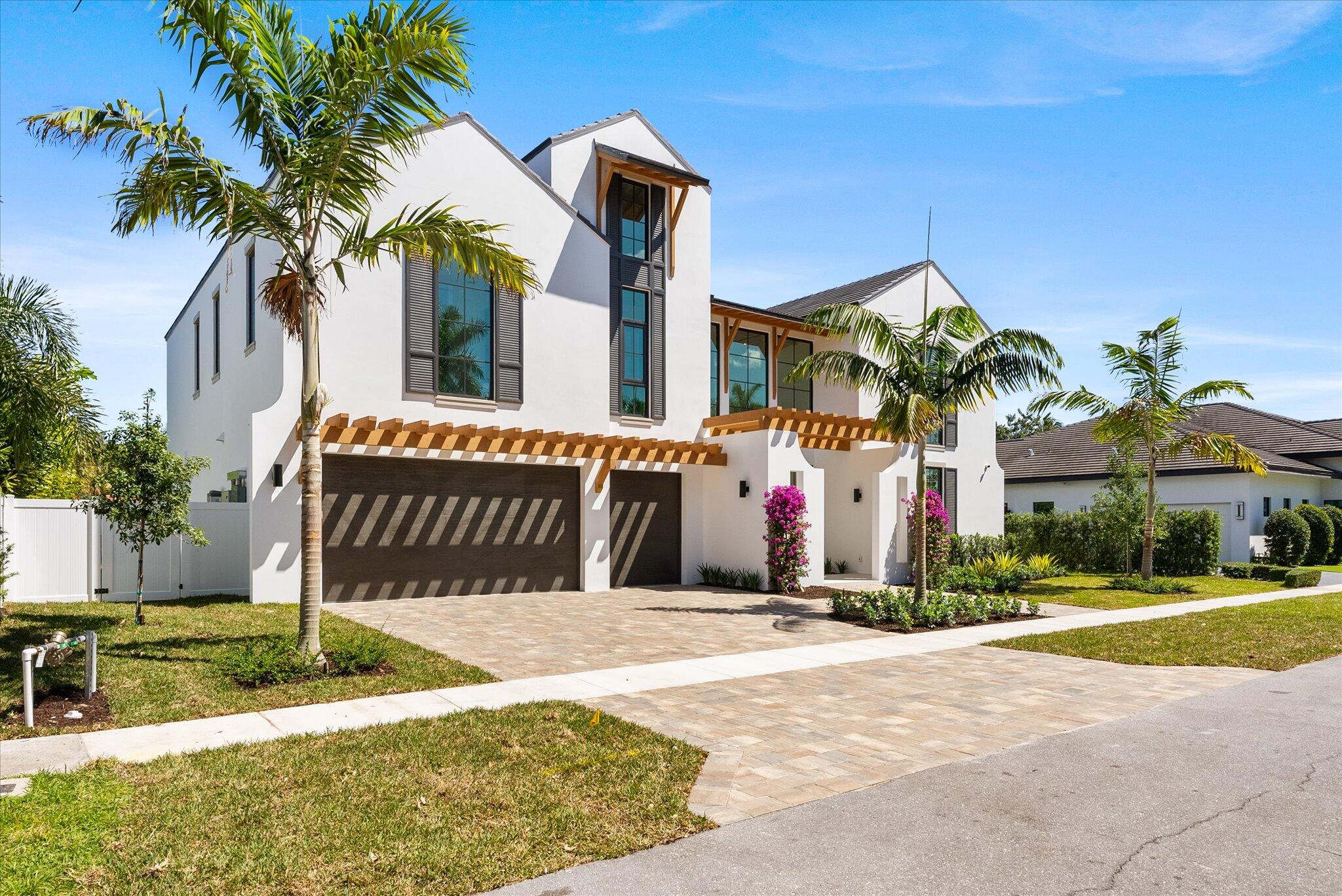 880 Northeast 3rd Avenue Boca Raton, FL 33432 - Photo 3 of 100 a front view of a house with a yard and palm trees