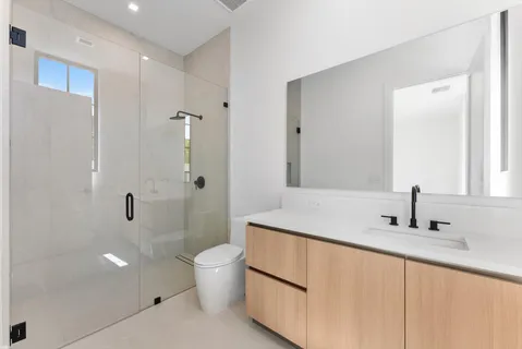 a bathroom with a granite countertop sink a toilet and shower