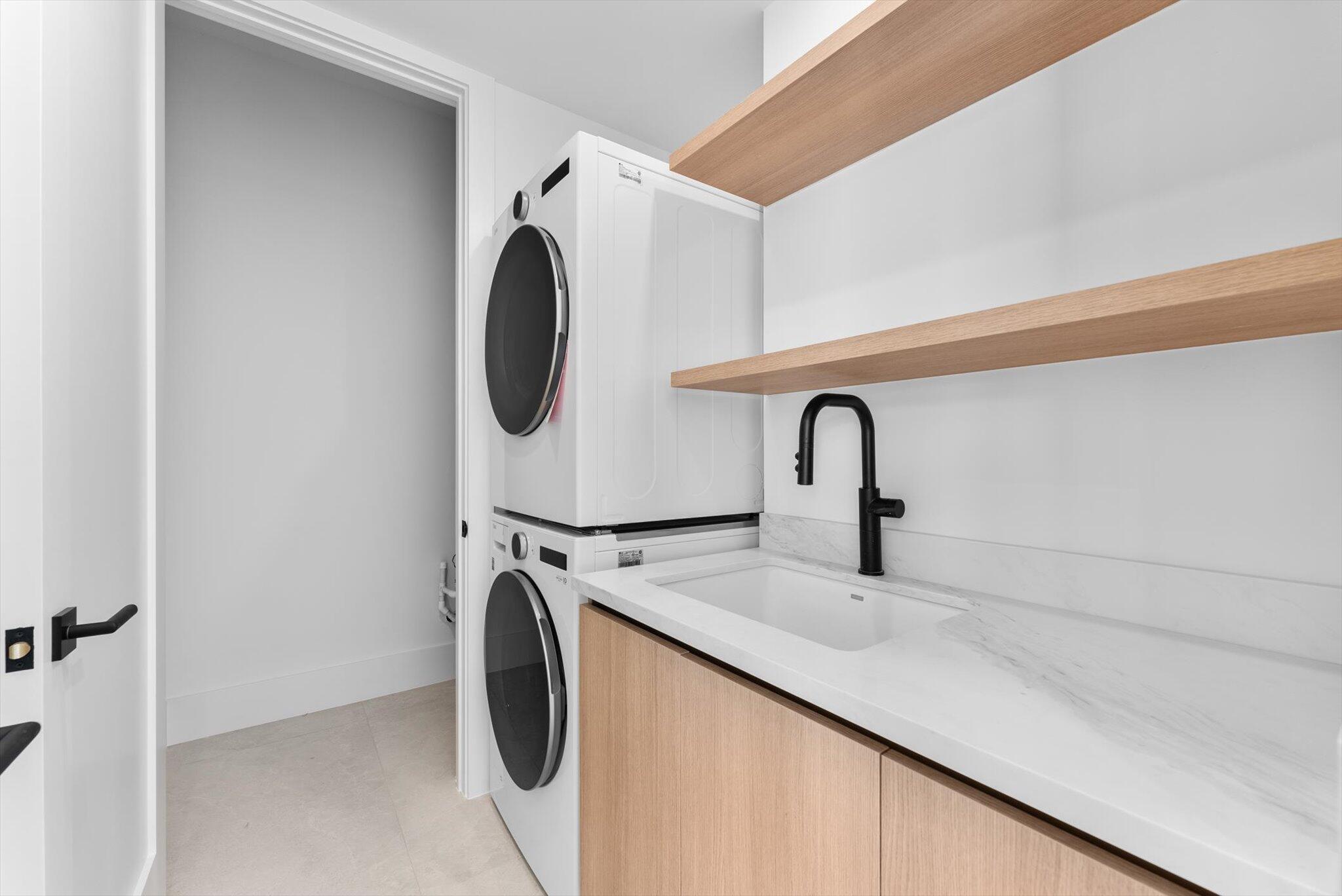 880 Northeast 3rd Avenue Boca Raton, FL 33432 - Photo 41 of 100 a close view of a sink and a dryer in a utility room