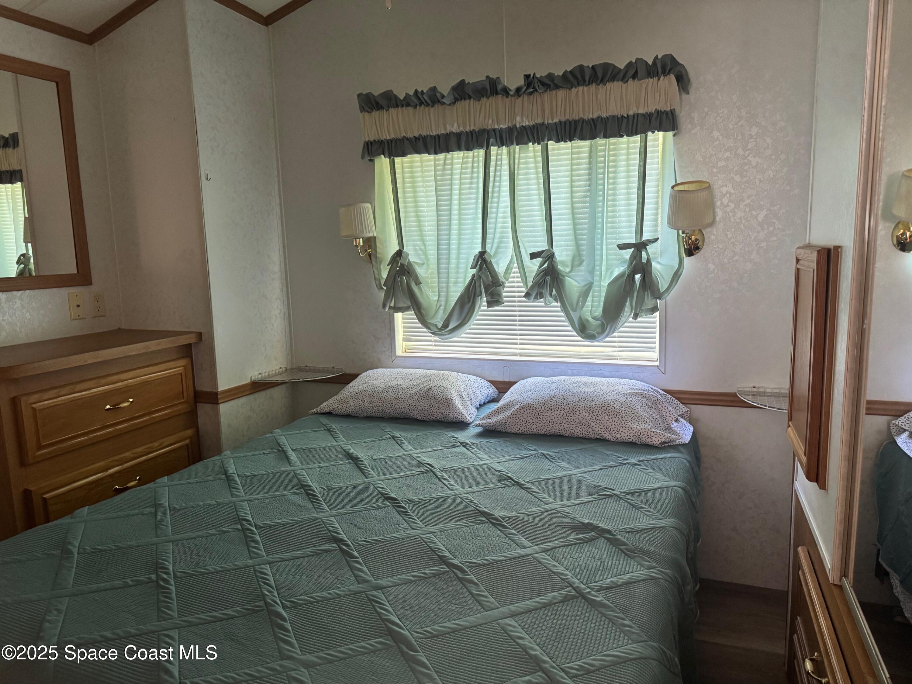 661 Snowbird Avenue, Unit 200 Cocoa, FL 32926 - Photo 6 of 7 a bedroom with a bed and a window