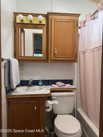 a bathroom with a granite countertop toilet sink and mirror