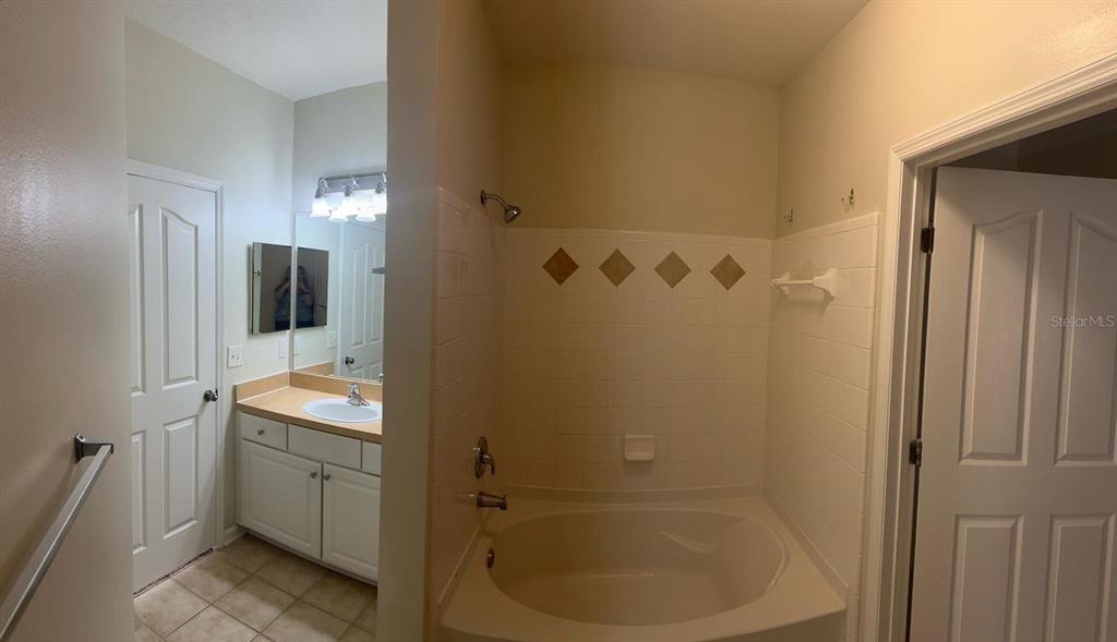 12861 Madison Pointe Circle, Unit 207 Orlando, FL 32821 - Photo 12 of 13 a bathroom with a sink and mirror