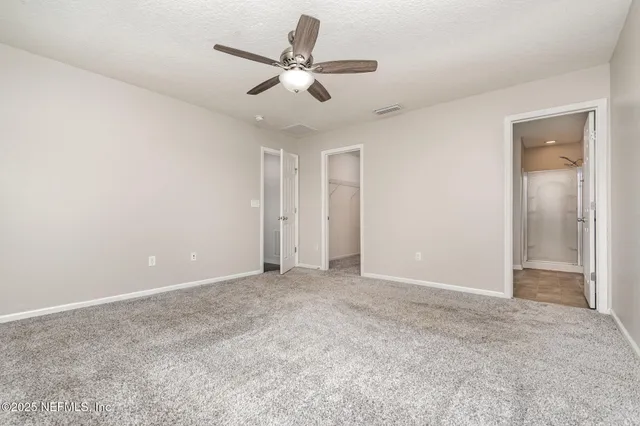 an empty room with a ceiling fan and a window