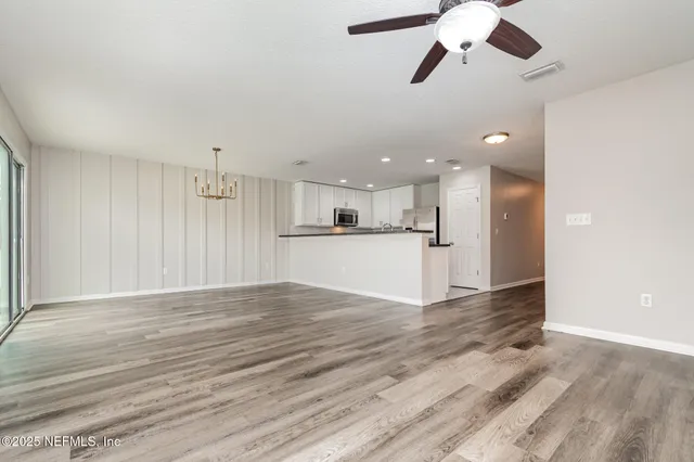 wooden floor in an empty room with a kitchen