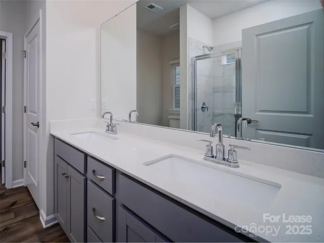 a bathroom with double vanity sinks and a mirror