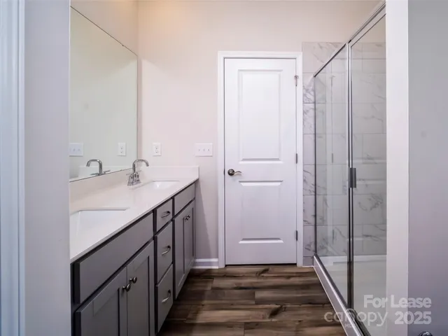 a bathroom with a sink a mirror and a shower