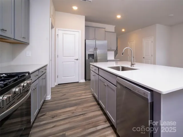a kitchen with stainless steel appliances granite countertop a sink stove and refrigerator