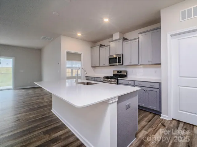 a kitchen with kitchen island a sink stainless steel appliances and cabinets