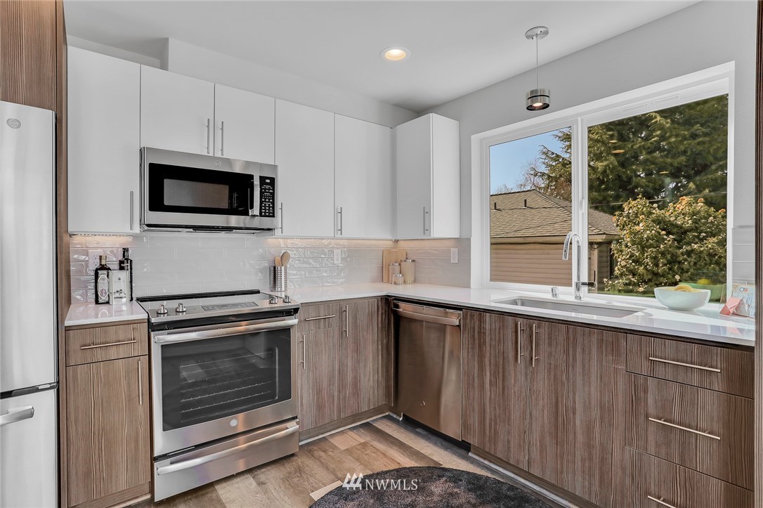 6249 8th Avenue Northwest Seattle, WA 98107 - Photo 12 of 31 a kitchen with granite countertop a stove top oven cabinetry a sink and a microwave