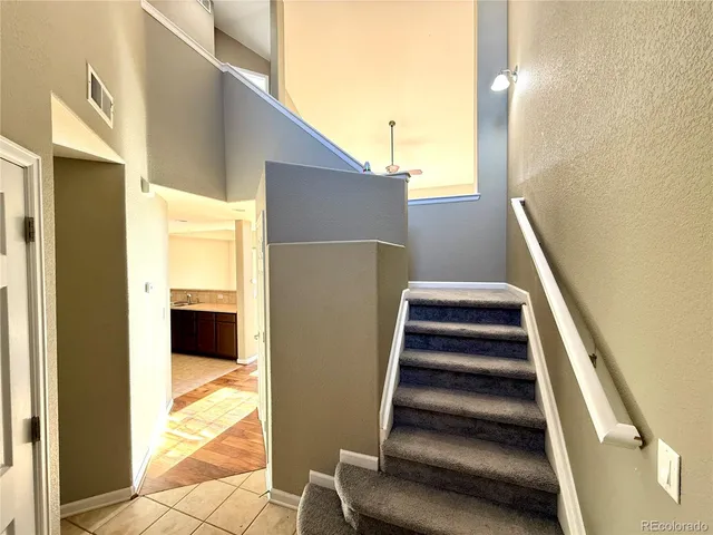 a view of a living room with wooden floor and windows