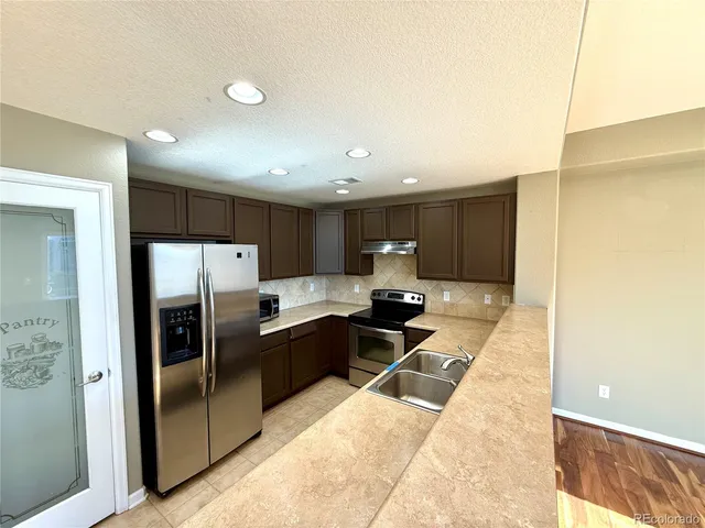 a kitchen with stainless steel appliances a refrigerator and a stove top oven