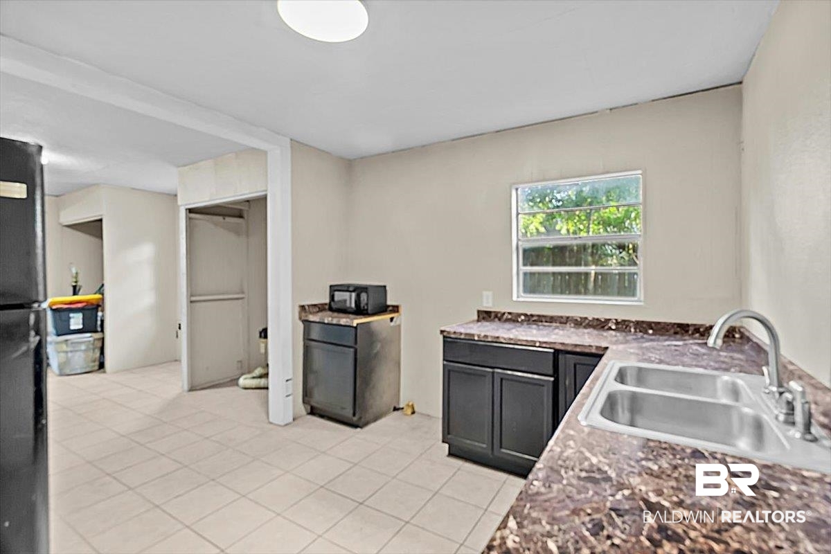 4918 Quimby Drive Mobile, AL 36619 - Photo 20 of 38 Kitchen featuring a sink, light tile patterned floors, and freestanding refrigerator