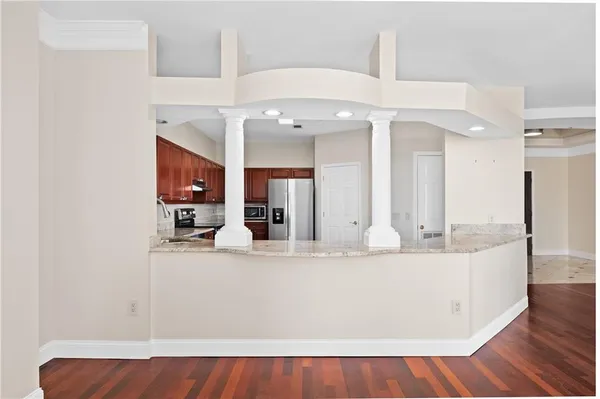 a large white kitchen with kitchen island a sink appliances and a couch