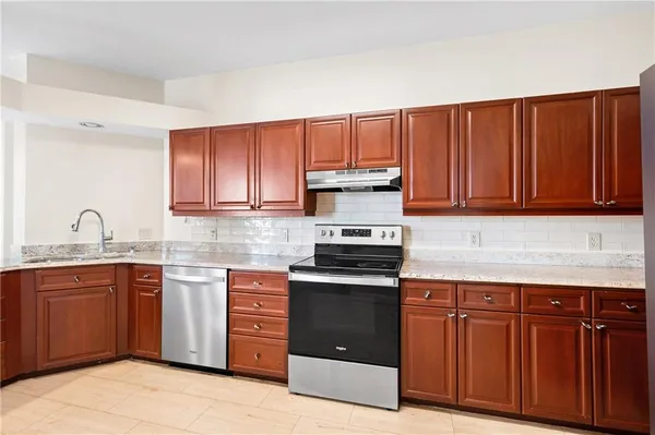 a kitchen with stainless steel appliances granite countertop a stove sink and cabinets