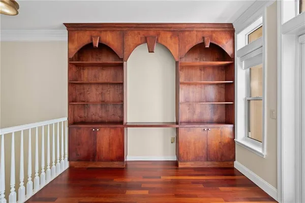a view of empty room with wooden floor and cabinet