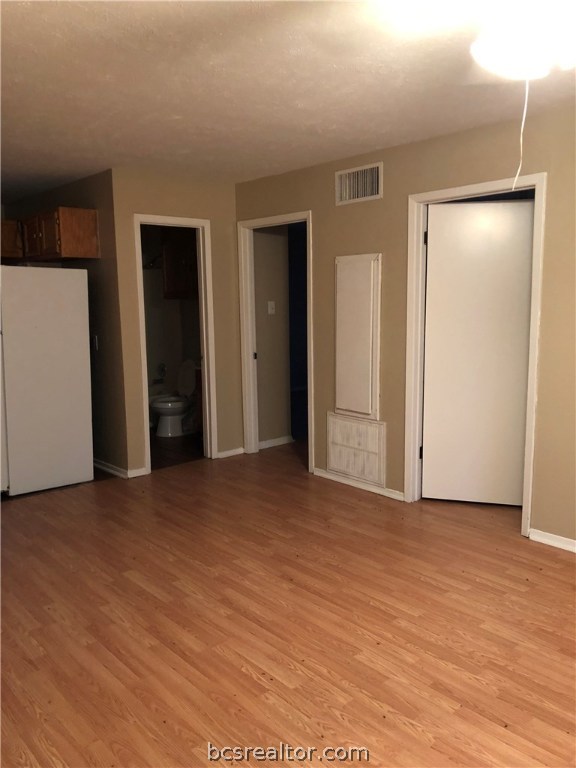 an empty room with closet and a bathroom