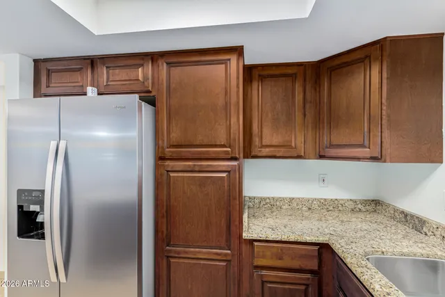 a kitchen with granite countertop stainless steel appliances and refrigerator