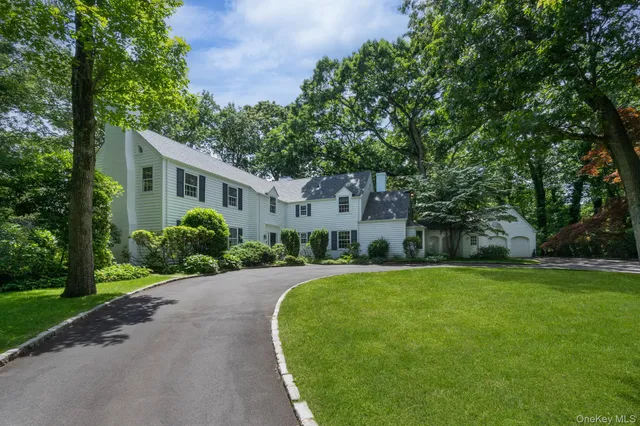 a front view of a house with a yard and trees