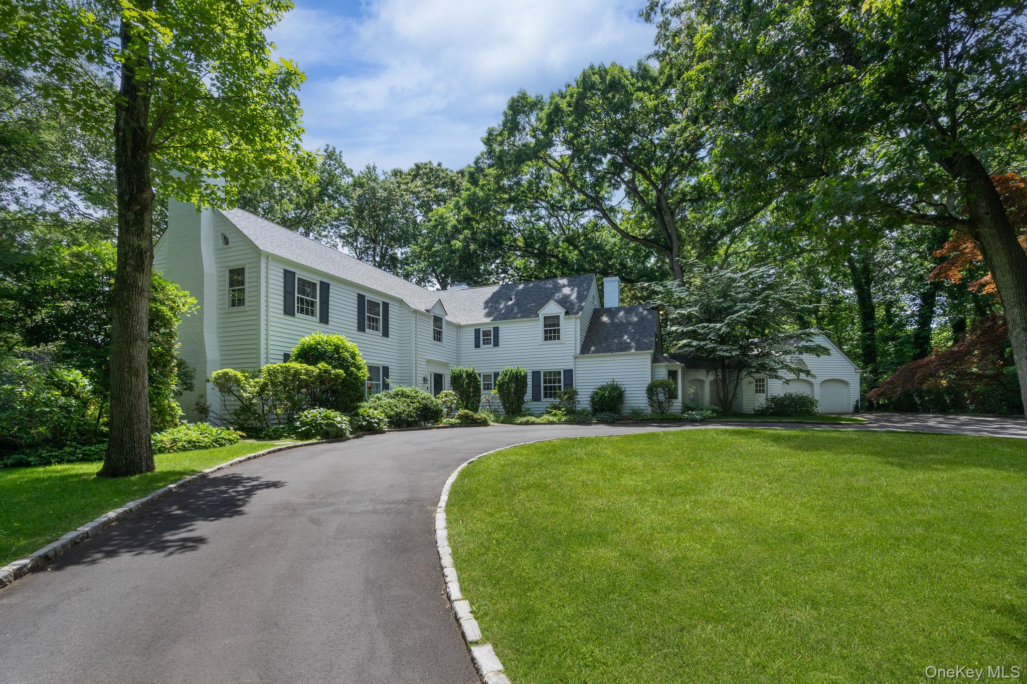 a front view of a house with a yard and trees