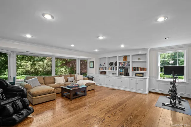 a living room with furniture floor to ceiling window and wooden floor