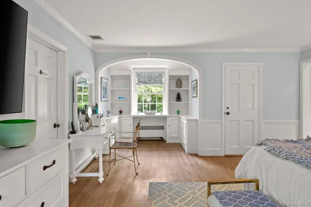 a bedroom with furniture and a large window