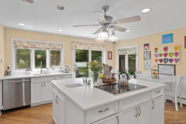 a kitchen with stainless steel appliances a center island cabinets and wooden floor