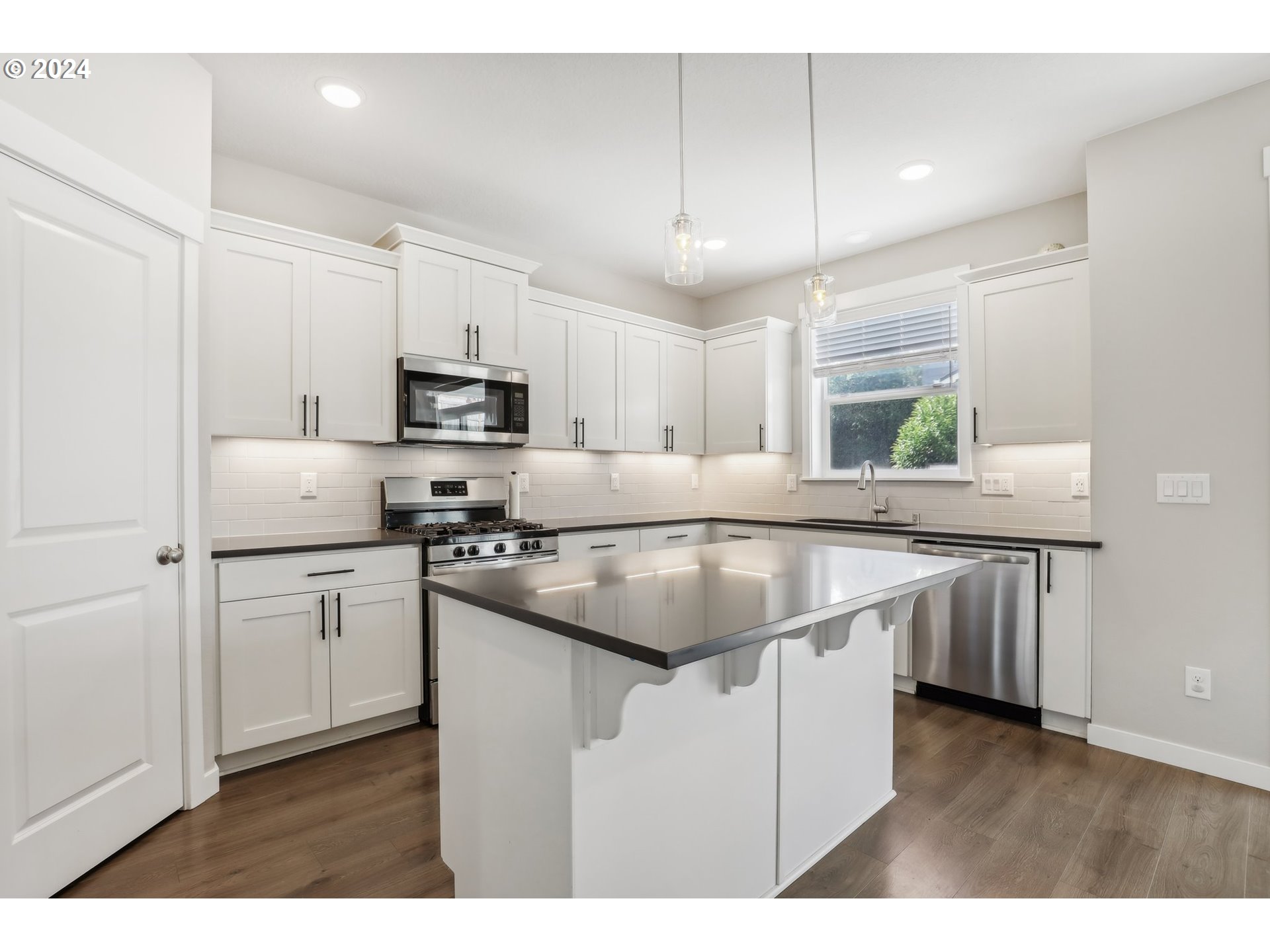 1817 Northeast 171st Street Ridgefield, WA 98642 - Photo 8 of 32 a kitchen with kitchen island granite countertop a sink window and stainless steel appliances