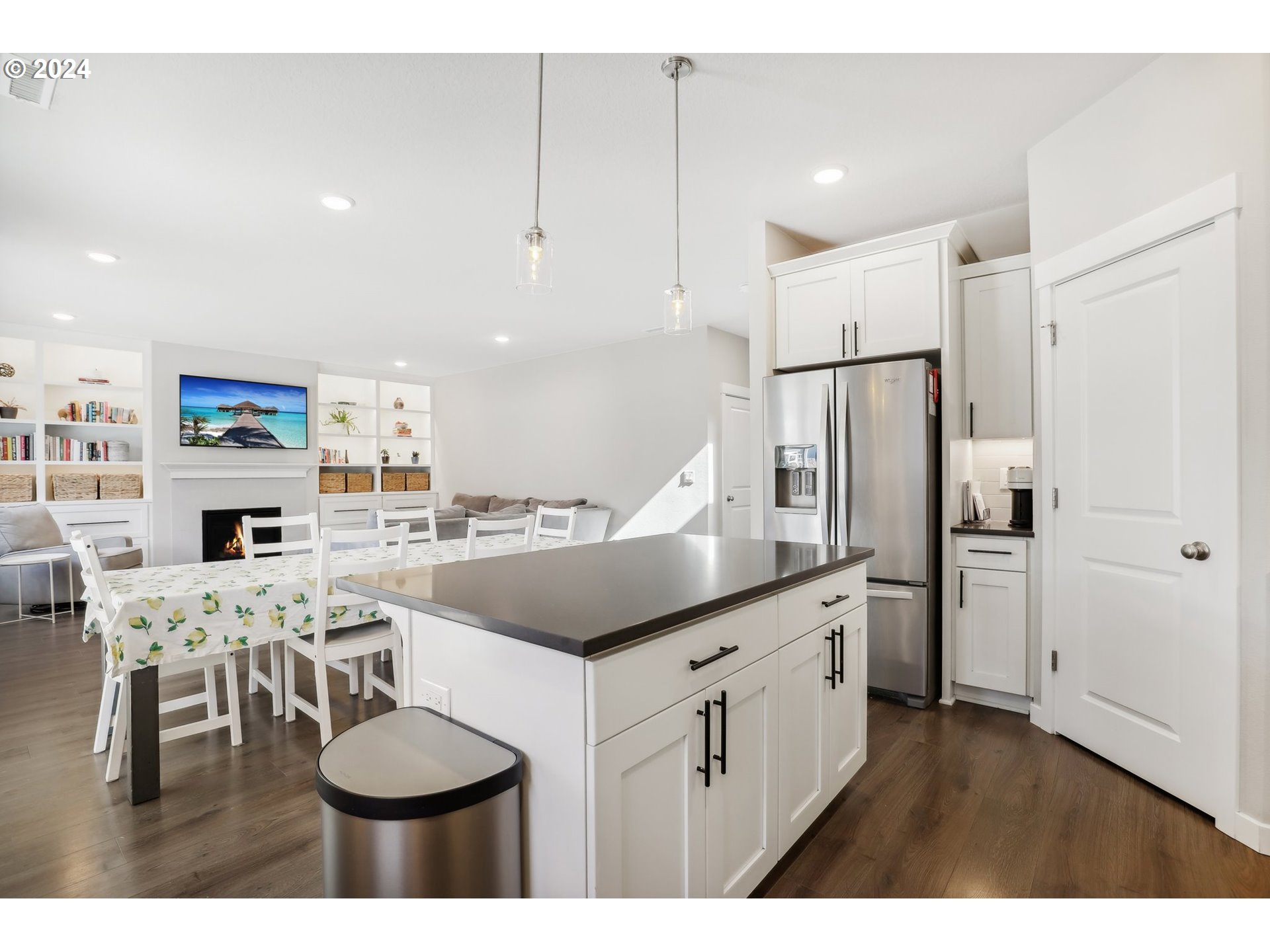1817 Northeast 171st Street Ridgefield, WA 98642 - Photo 10 of 32 a kitchen with stainless steel appliances kitchen island granite countertop a refrigerator a stove a sink a dining table and chairs with wooden floor