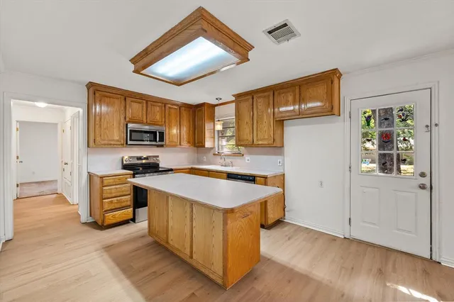 a kitchen with cabinets and wooden floor