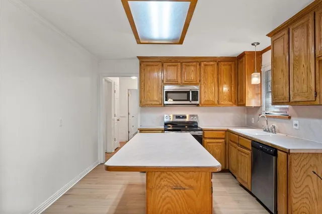 a kitchen with stainless steel appliances a stove sink microwave and cabinets