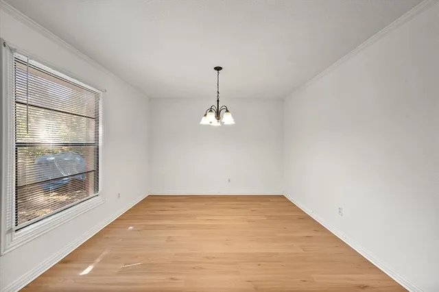 a view of a room with a large window and wooden floor