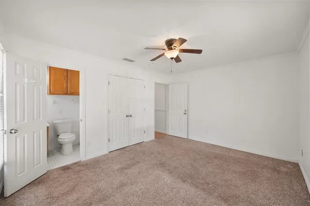 a view of a big room with a chandelier fan and a bathroom