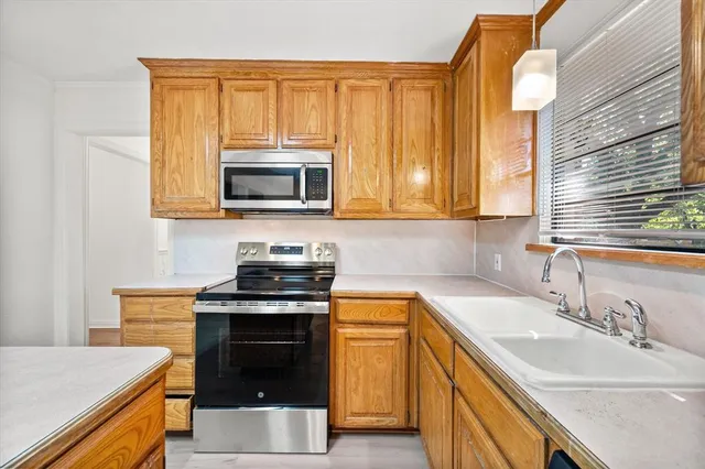a kitchen with a stove a sink and a microwave