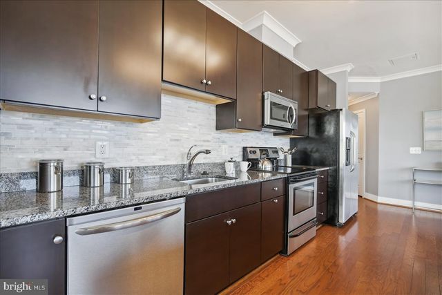 a kitchen with stainless steel appliances a stove microwave and sink