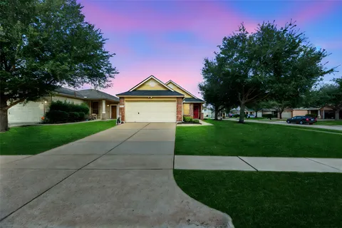 a front view of a house with a garden and yard