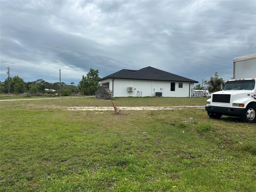 3401 Sand Road Cape Coral, FL 33993 - Photo 3 of 27 a front view of a house with a garden and lake view
