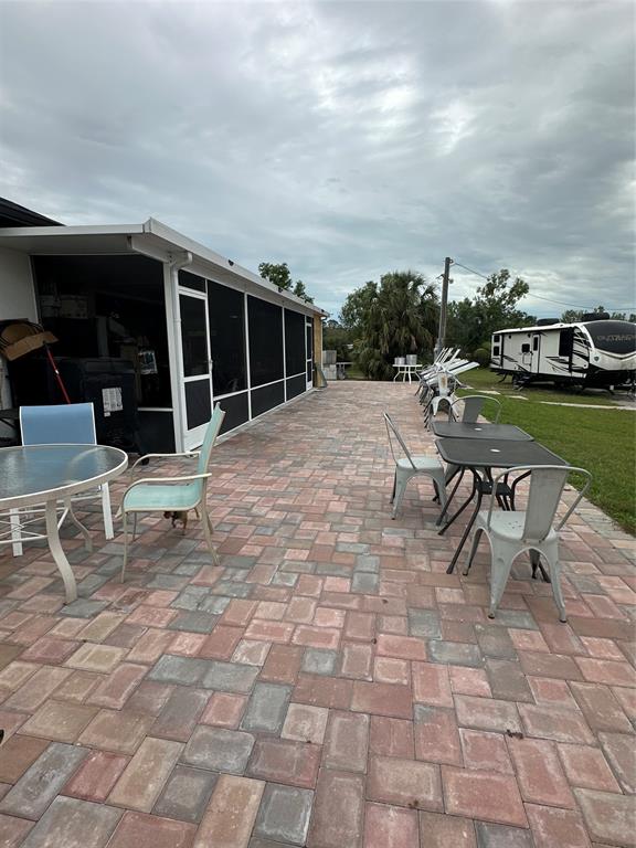 3401 Sand Road Cape Coral, FL 33993 - Photo 10 of 27 a roof deck with table and chairs and potted plants