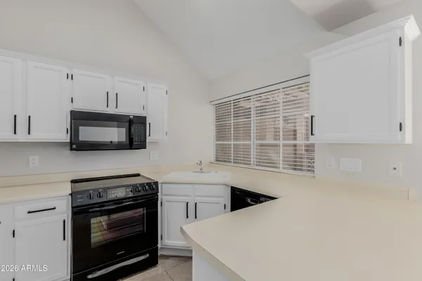 a kitchen with a sink a window and cabinets