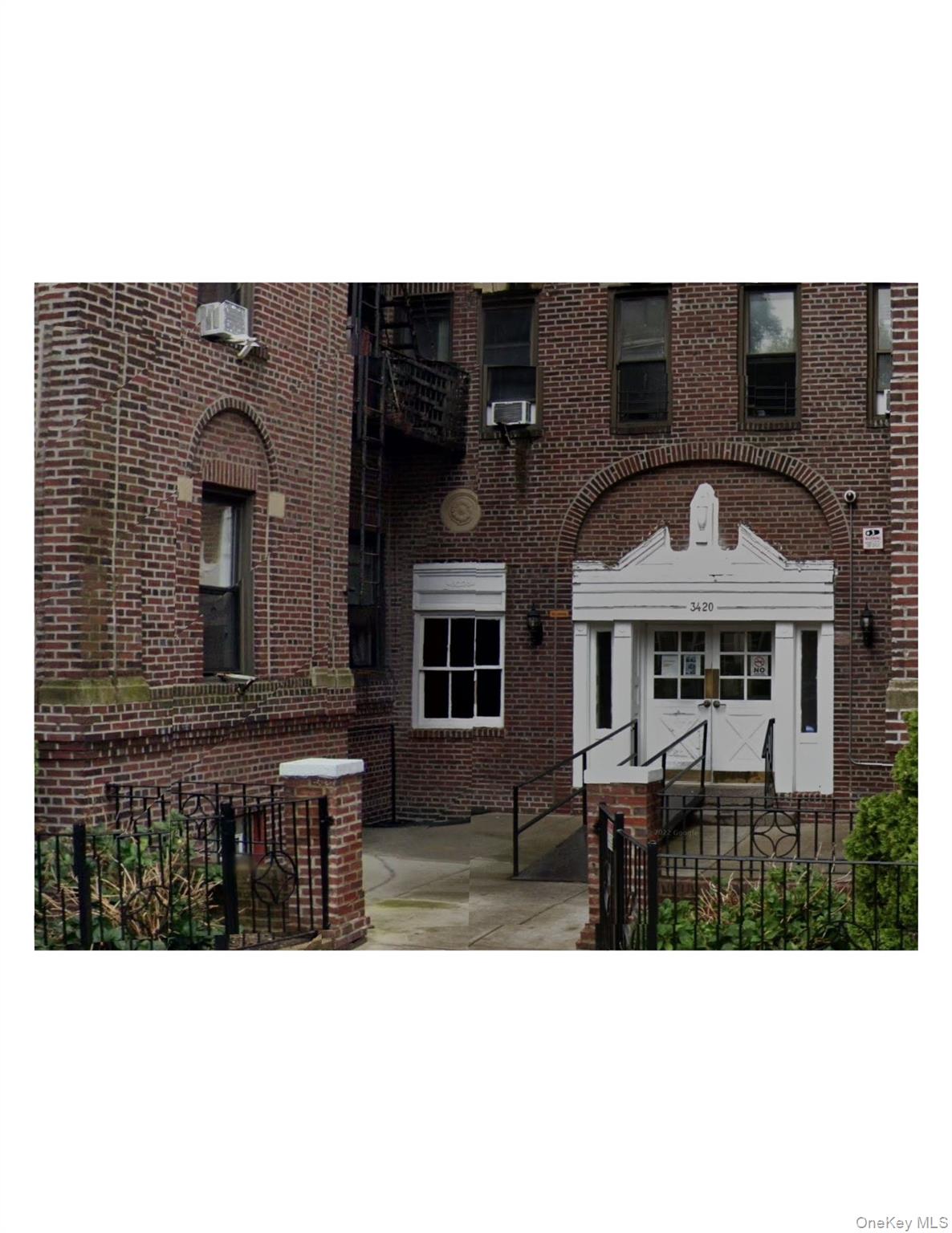 3420 83rd Street, Unit 1A Queens, NY 11372 - Photo 1 of 1 View of front of house featuring cooling unit, fence, and brick siding