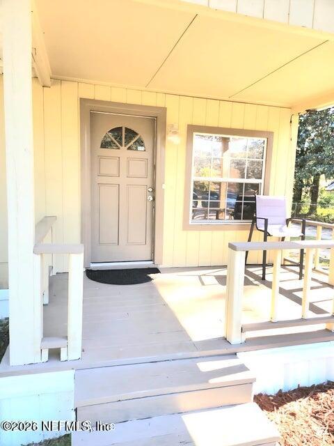 6107 Carlton Road Jacksonville, FL 32244 - Photo 5 of 39 a living room with a fireplace windows and a dining table with wooden floor